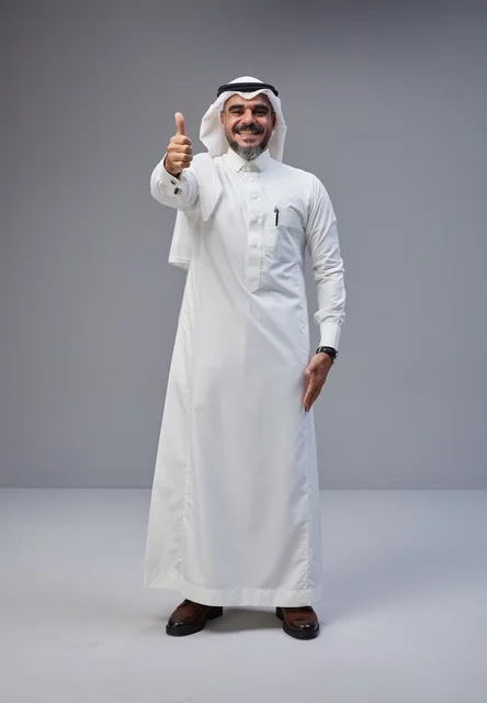 رجل سعودي بالزي التقليدي يشير بعلامة الإعجاب