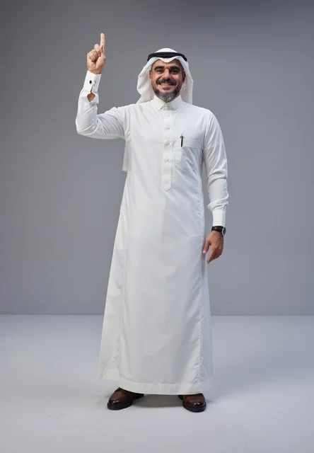 رجل سعودي بالزي التقليدي يشير للأعلى في استوديو