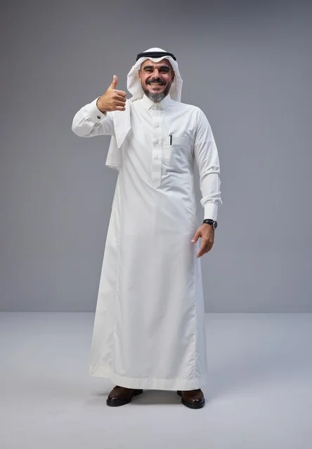 رجل سعودي بالزي التقليدي يشير بعلامة الإعجاب