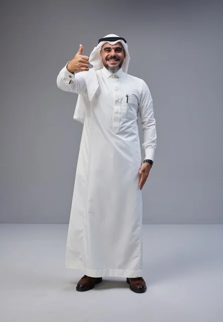 رجل سعودي بالزي التقليدي يشير بعلامة الإبهام