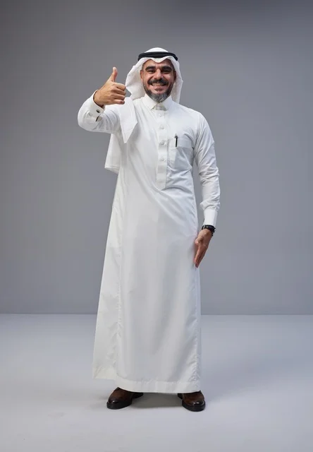 رجل سعودي بالزي التقليدي يرفع إبهامه للإعجاب