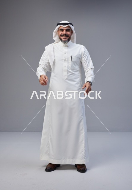 رجل سعودي بالزي التقليدي في استوديو خلفية رمادية