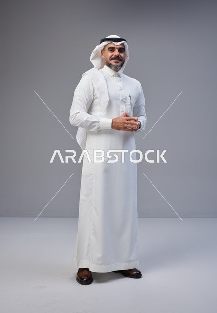 رجل سعودي بالزي التقليدي يقف في استوديو