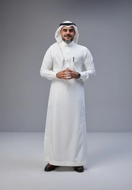 رجل سعودي بالزي التقليدي في استوديو بخلفية رمادية