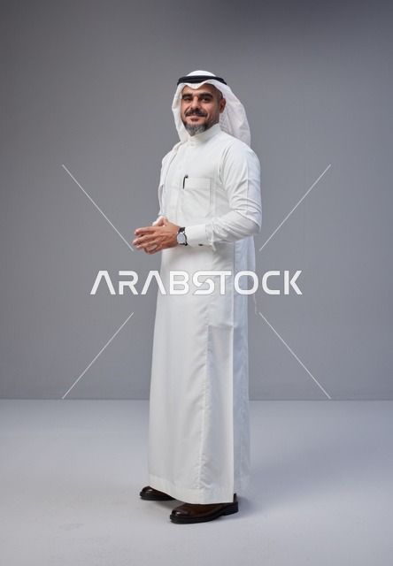 رجل سعودي بالزي التقليدي يقف في استوديو
