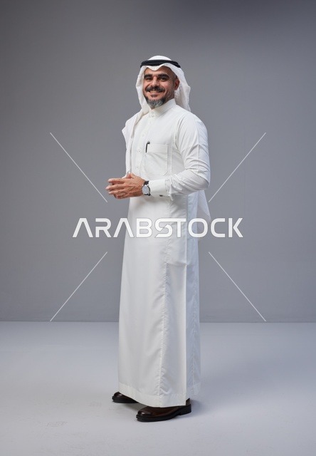 رجل سعودي بالزي التقليدي على خلفية رمادية