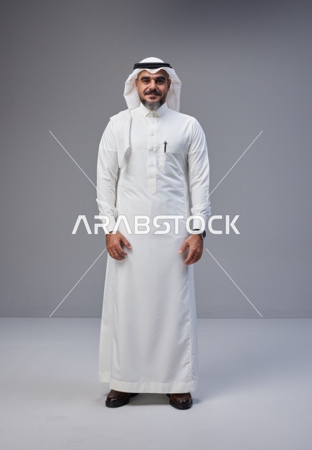 رجل سعودي بالزي التقليدي يقف في استوديو