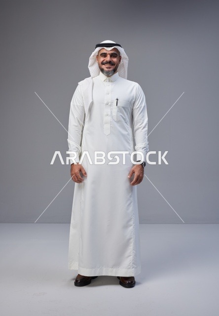 رجل سعودي بالزي التقليدي في استوديو خلفية رمادية