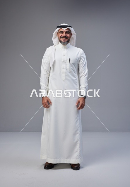 رجل سعودي بالزي التقليدي يقف في استوديو