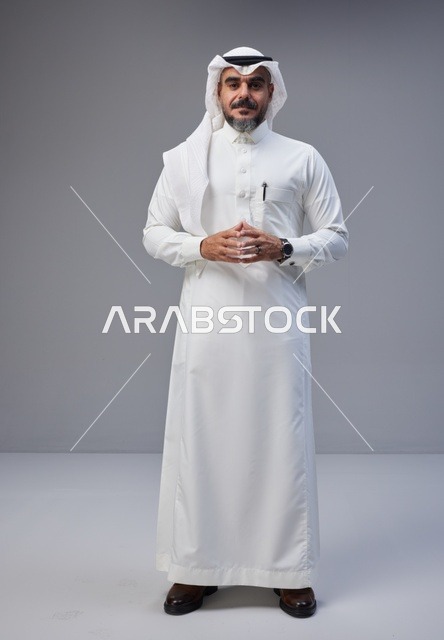 رجل سعودي بالزي التقليدي يقف في الاستوديو