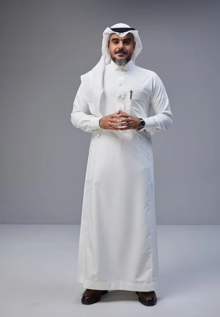 رجل سعودي بالزي التقليدي يقف في الاستوديو