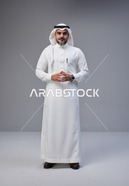 رجل سعودي بالزي التقليدي يقف في استوديو