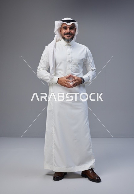 رجل سعودي بالزي التقليدي يقف في استوديو