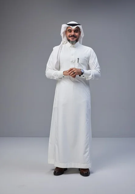 رجل سعودي بالزي التقليدي يقف في استوديو