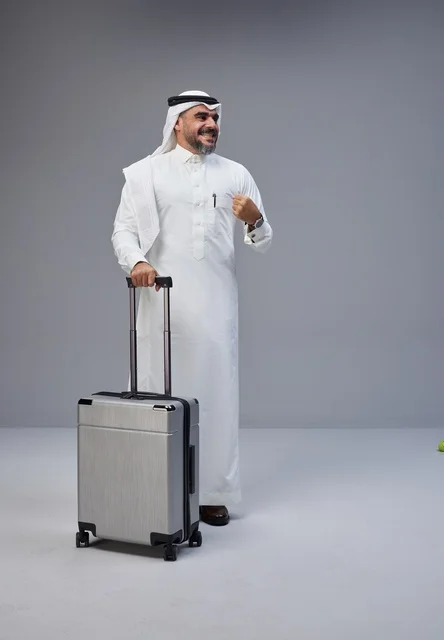 رجل سعودي بالزي التقليدي مع حقيبة سفر