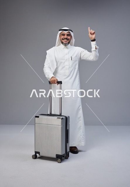 رجل سعودي مع حقيبة سفر يشير للأعلى
