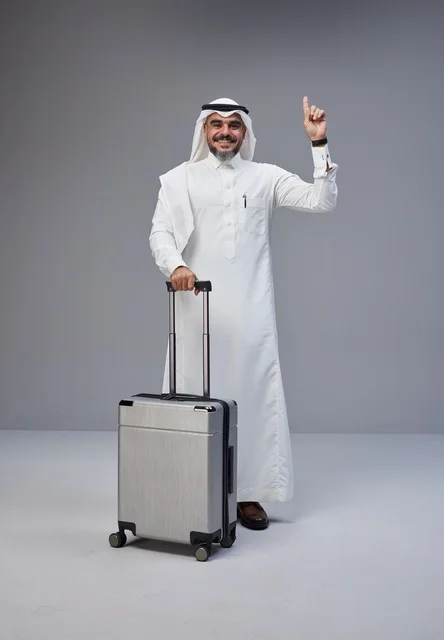 رجل سعودي بالزي التقليدي مع حقيبة سفر يشير للأعلى