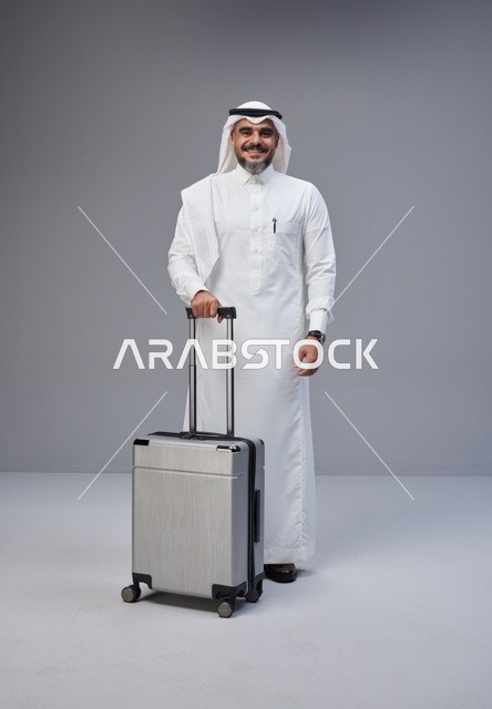 رجل سعودي بالزي التقليدي مع حقيبة سفر