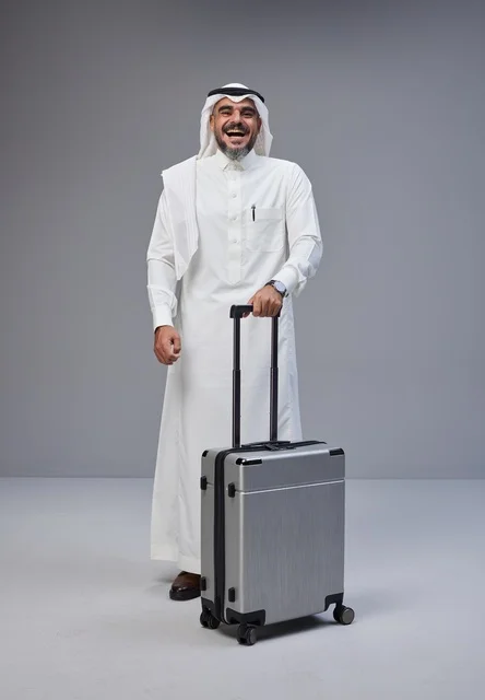 Saudi Man in Traditional Dress with Suitcase