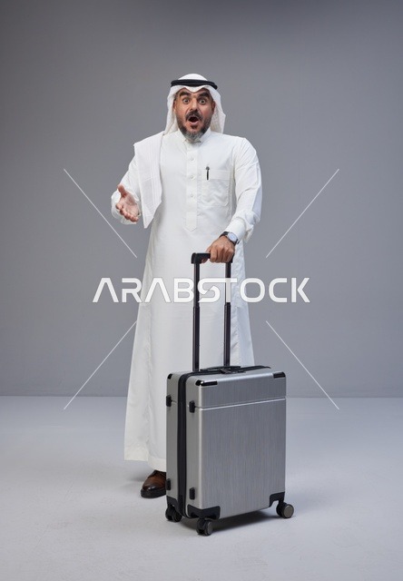 Surprised Saudi Man with Suitcase on Grey Background