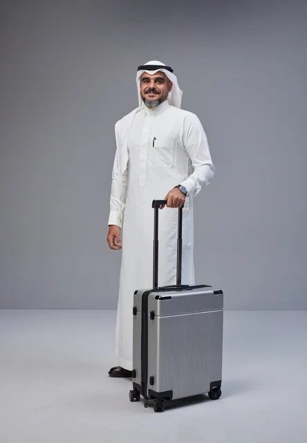 Saudi Man in Traditional Thobe with Silver Suitcase