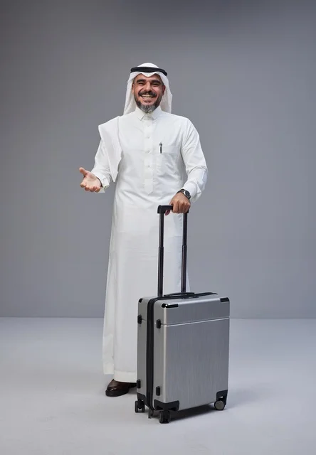 رجل سعودي بالزي التقليدي مع حقيبة سفر فضية