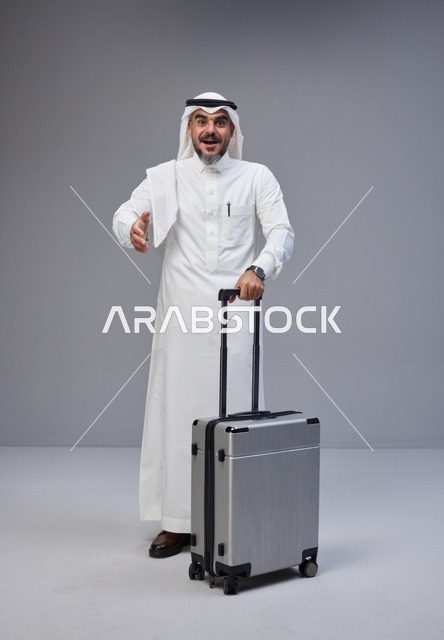 رجل سعودي بالزي التقليدي مع حقيبة سفر
