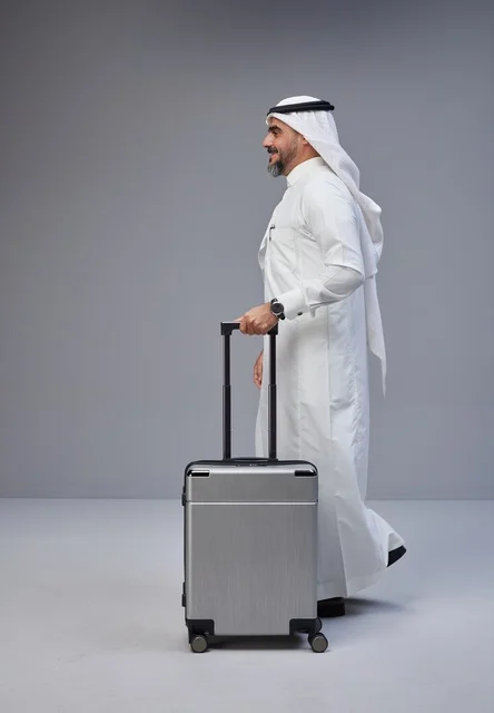 رجل سعودي يمشي مع حقيبة سفر في الاستوديو