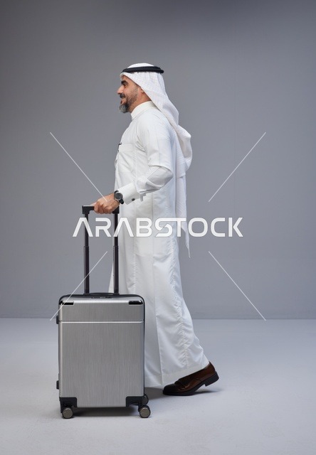 رجل سعودي بالزي التقليدي مع حقيبة سفر