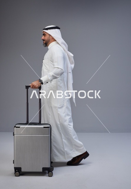 رجل سعودي بالزي التقليدي مع حقيبة سفر