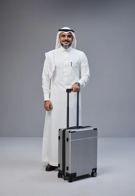 Saudi Man in Traditional Thobe with Silver Suitcase