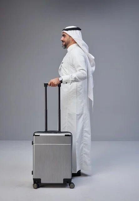 Saudi Man in Traditional Thobe with Silver Suitcase Saudi Man in Traditional Thobe with Silver Suitcase