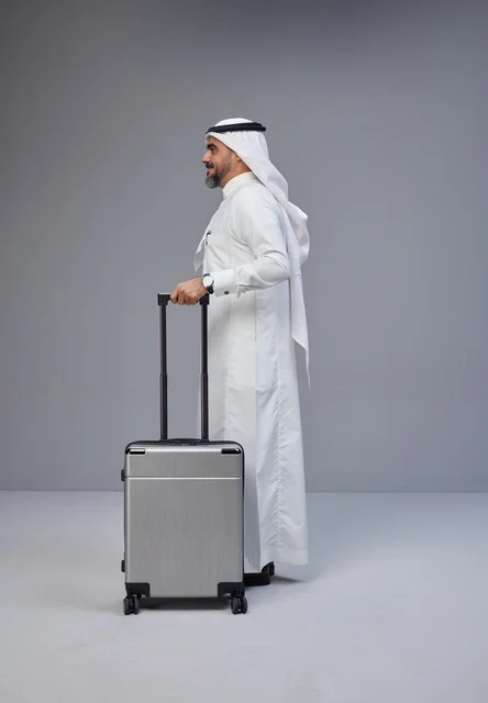 Saudi Man in Traditional Thobe with Silver Suitcase