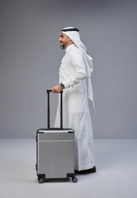 رجل سعودي بالزي التقليدي مع حقيبة سفر في الاستوديو