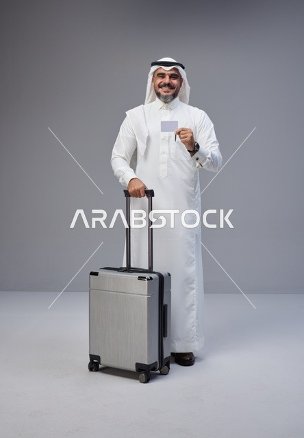 Saudi Man with Suitcase and Blank Card on Grey Background