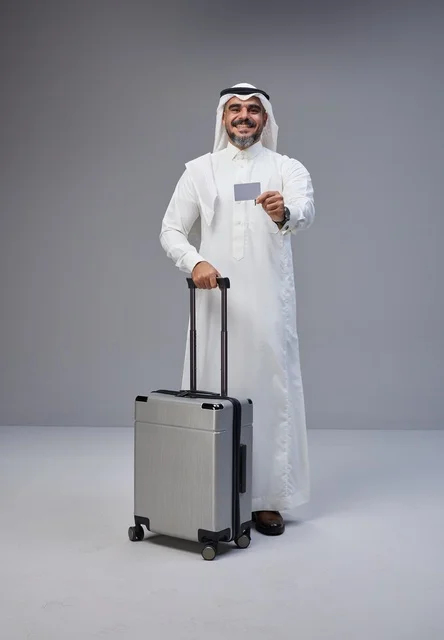 رجل سعودي مع حقيبة سفر وبطاقة ائتمان في الاستوديو