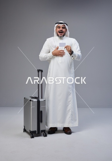رجل سعودي مع حقيبة سفر وبطاقة ائتمان في الاستوديو
