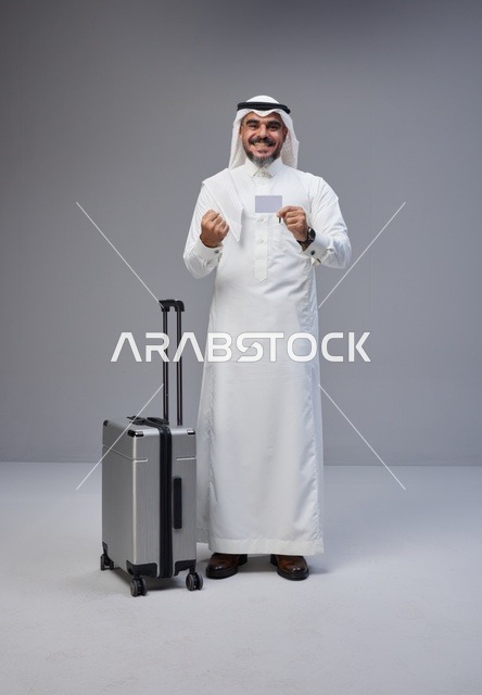 رجل سعودي مع حقيبة سفر يحمل بطاقة ائتمانية