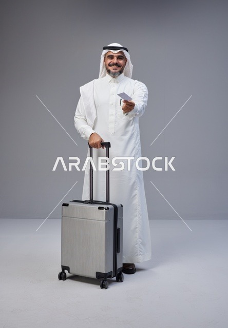 رجل سعودي مع حقيبة سفر وبطاقة في الاستوديو