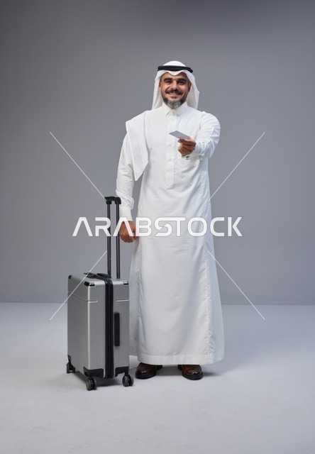 رجل سعودي مع حقيبة سفر يحمل بطاقة في الاستوديو