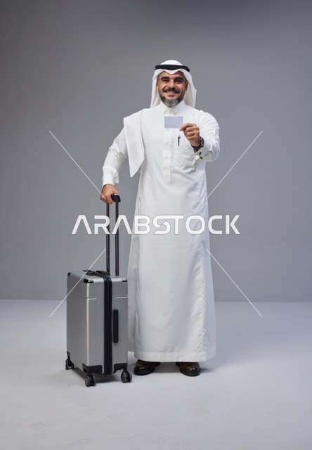 رجل سعودي مع حقيبة سفر وبطاقة بنكية في الاستوديو
