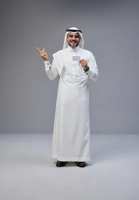 رجل سعودي بالزي التقليدي يحمل بطاقة تعريف فارغة