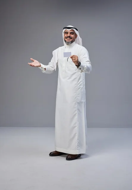 رجل سعودي بالزي التقليدي يحمل بطاقة تعريف فارغة