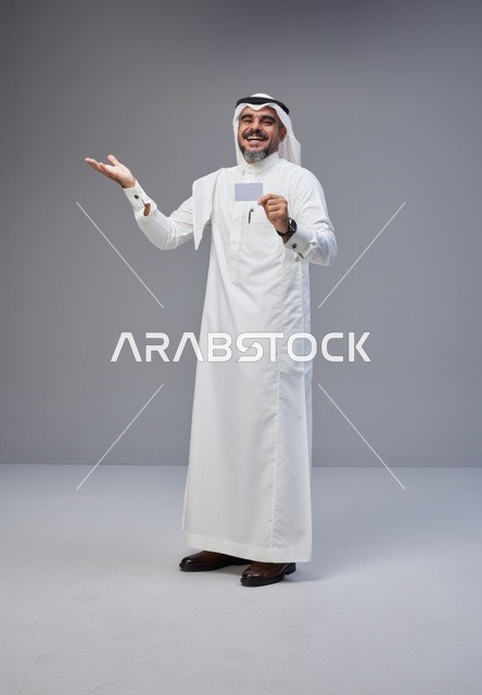 رجل سعودي يحمل بطاقة تعريف فارغة في الاستوديو