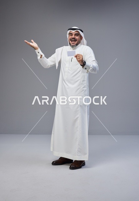 رجل سعودي يحمل بطاقة تعريف فارغة في استوديو