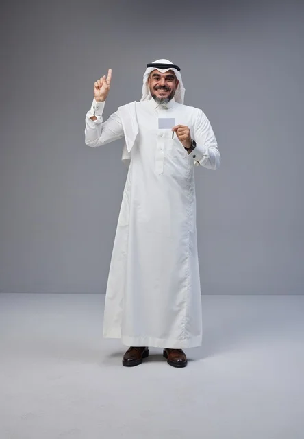رجل سعودي بالزي التقليدي يحمل بطاقة تعريف فارغة