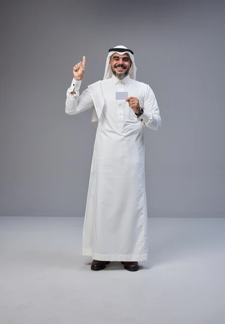 رجل سعودي بالزي التقليدي يحمل بطاقة تعريف فارغة
