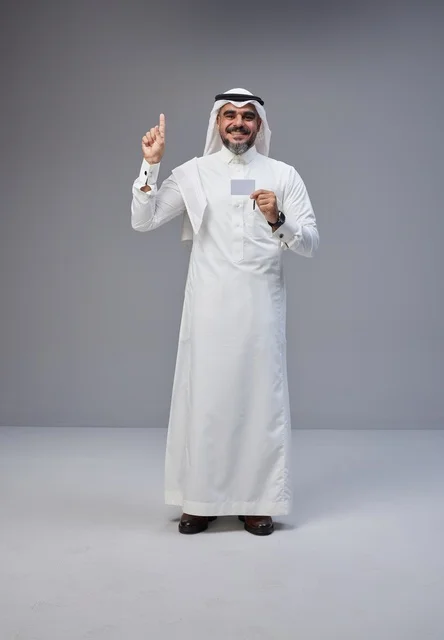 رجل سعودي بالزي التقليدي يحمل بطاقة تعريف فارغة