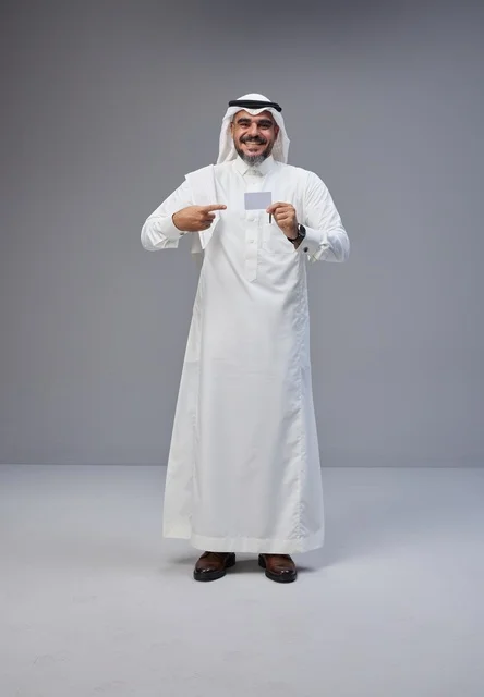 رجل سعودي بالزي التقليدي يحمل بطاقة تعريفية فارغة