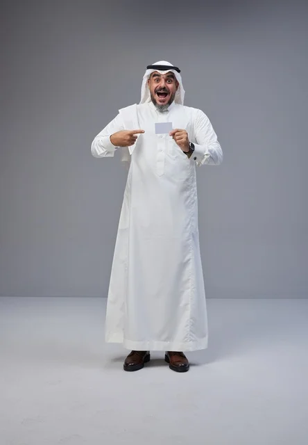 رجل سعودي بالزي التقليدي يحمل بطاقة تعريفية فارغة رجل سعودي بالزي التقليدي يحمل بطاقة تعريفية فارغة
